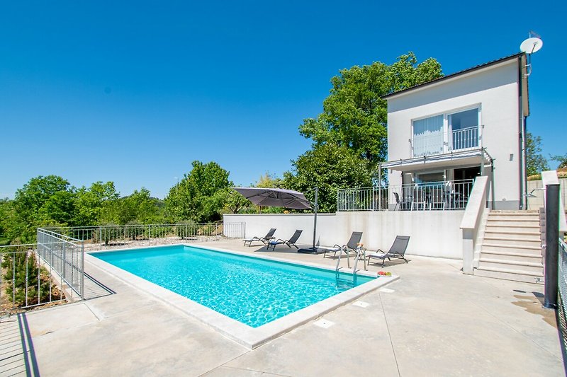 Luxusvilla mit Pool, Garten, moderner Architektur und atemberaubender Aussicht.