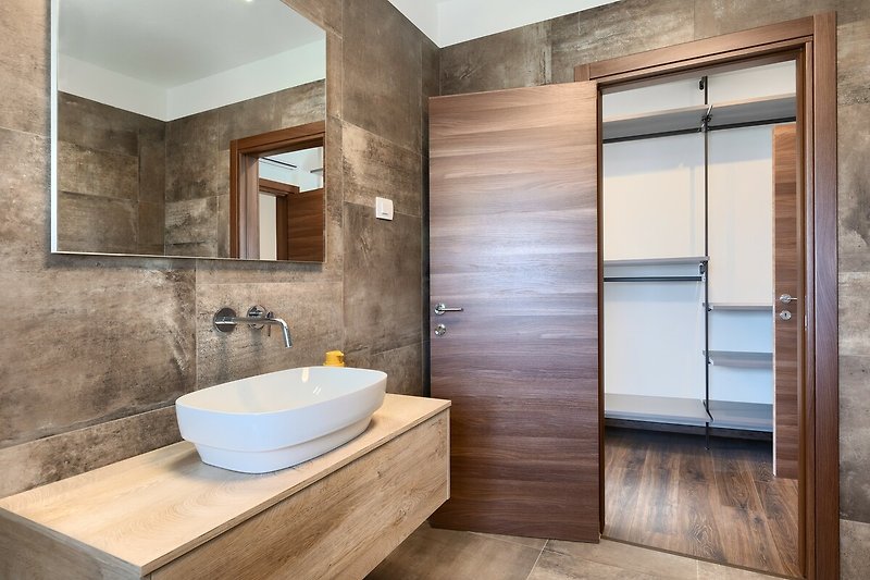 Ein stilvolles Badezimmer mit Spiegel, Waschbecken und modernen Armaturen.