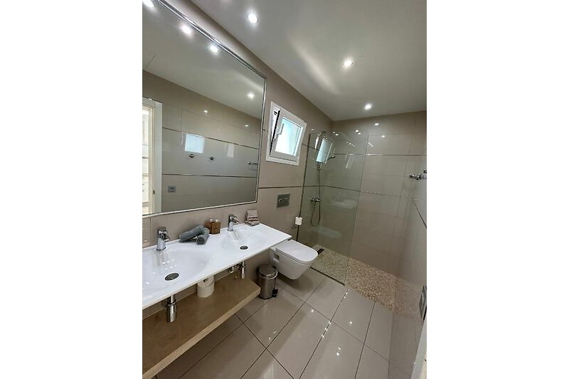 Modernes Badezimmer mit ebenerdiger Dusche und Doppelwaschbecken
