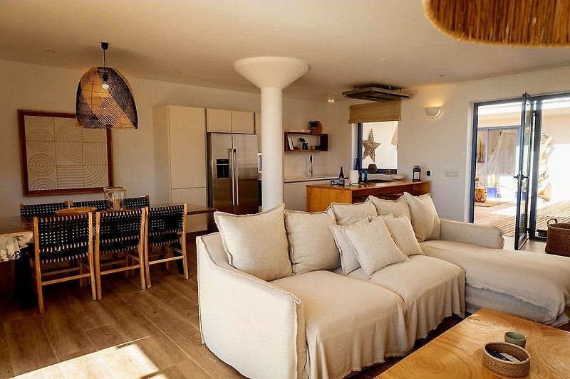 Stilvolles Wohnzimmer mit Holzmöbeln, bequemer Couch und dekorativer Beleuchtung.