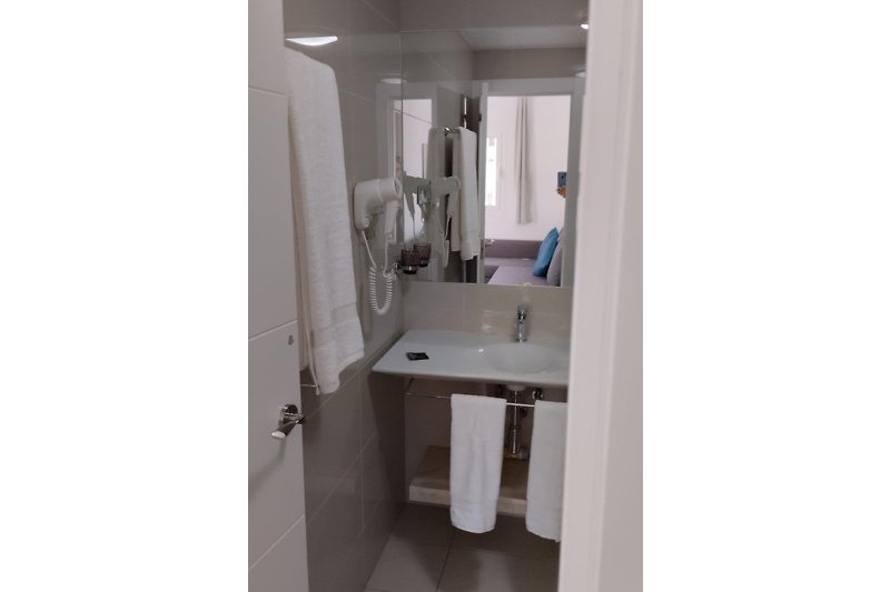 Modernes Badezimmer mit Spiegel, Waschbecken und Fön