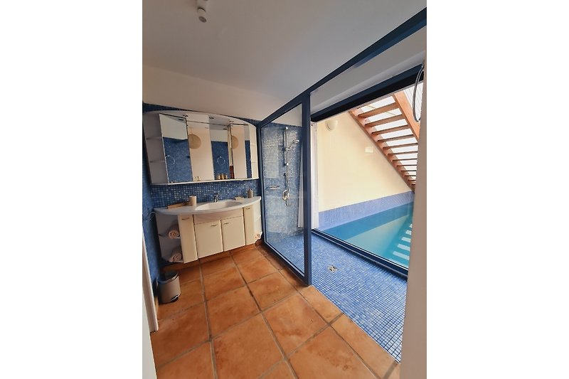 Schönes Badezimmer mit Holzschrank, Waschbecken und Fliesenboden.