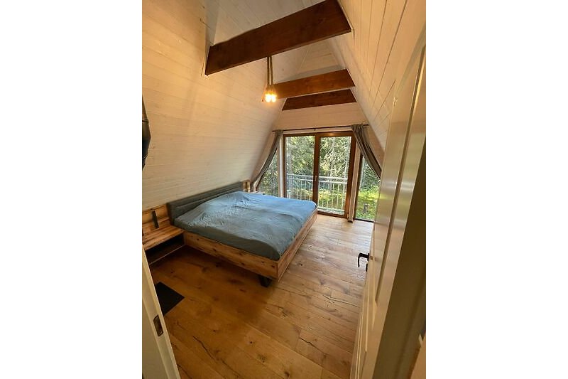 Gemütliches Ferienhaus mit Holzinterieur, bequemem Bett und schöner Aussicht. Perfekt zum Entspannen und die Natur genießen.