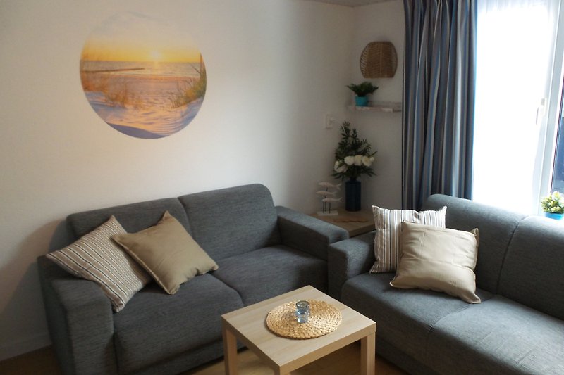 Gemütliches Wohnzimmer mit bequemer Couch, Tisch und stilvoller Beleuchtung.