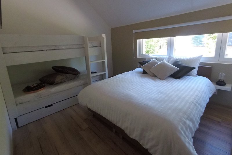 Slaapkamer 1 met 2-persoons bed en stapelbed en TV  vakantiehuis La Couronne, Barvaux - Durbuy