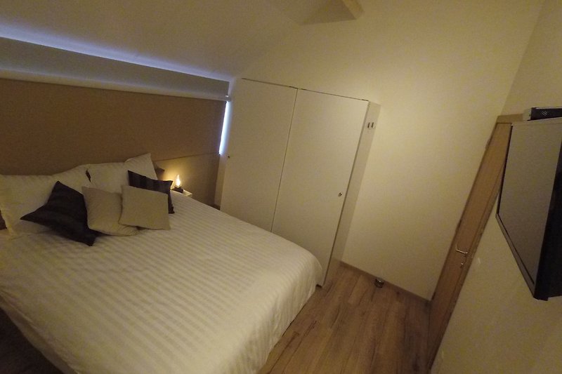 Slaapkamer 1 met 2-persoons bed en stapelbed en TV  vakantiehuis La Couronne, Barvaux - Durbuy