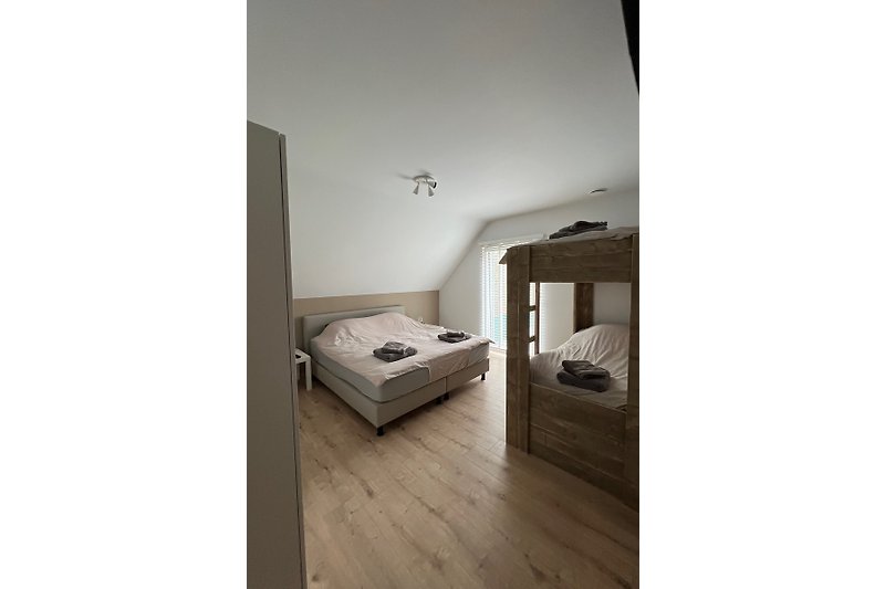 5e slaapkamer met 2-persoons bed en een (volwassen) stapelbed van steigerhout
