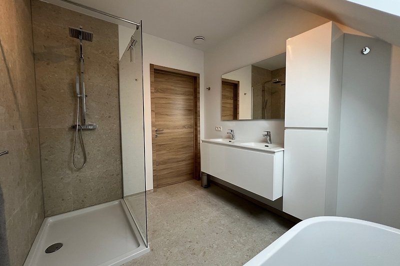 3e badkamer met dubbele wastafel, extra kast, ruime inloopdouche en een heerlijk bad