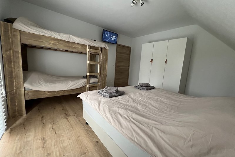 Schlafzimmer mit gemütlichem Bett und Holzakzenten.