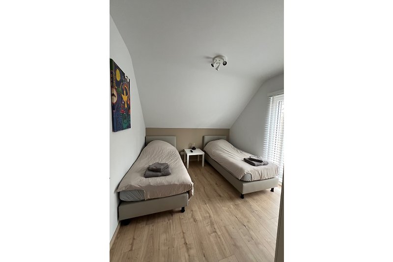 Monochromes Zimmer mit metallischem Regal und Holzboden.