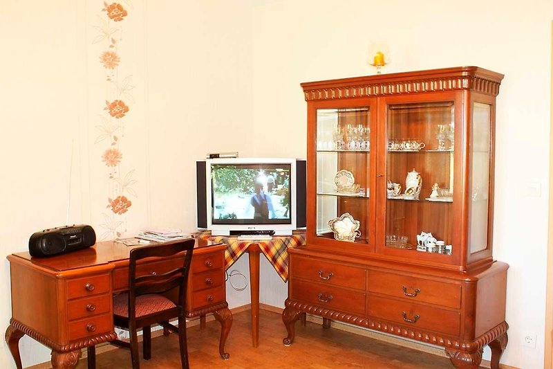 Wohnzimmer mit Schreibtisch und TV