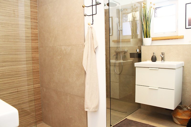 Ein stilvolles Badezimmer mit Spiegel, Waschbecken und bodengleicher Dusche