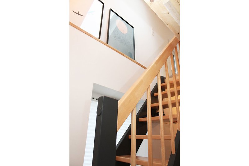 A wooden staircase leads to the upper sleeping area