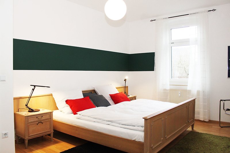 Schlafzimmer mit großem Doppelbett Bett, stilvoller Beleuchtung und Holzmöbeln.