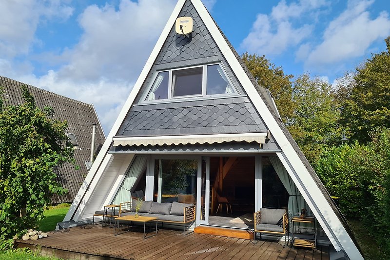 Ein idyllisches Holzhaus mit einem strohgedeckten Dach und einer grünen Umgebung.