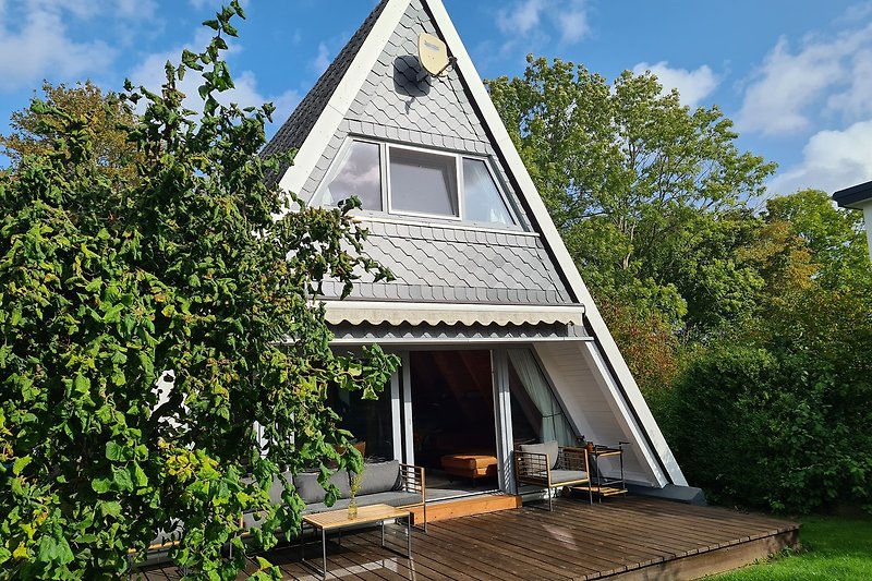Ein charmantes Holzhaus mit einem strohgedeckten Dach und einer grünen Umgebung.
