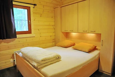 Modernes Holzchalet im Wald, mit Holzofen
