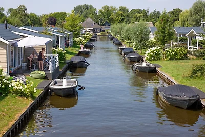 Huisje aan het meer met boot
