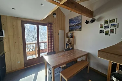Refugio alpino con balcón y aparcamiento.