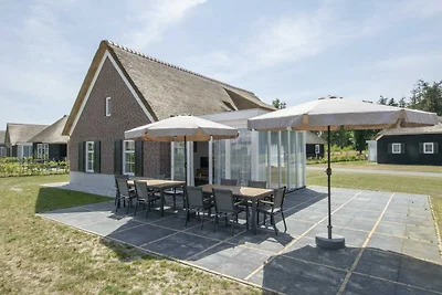 Villa dal tetto di paglia in un parco vacanze