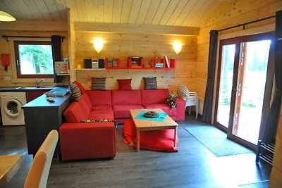 Modernes Holzchalet im Wald, mit Holzofen