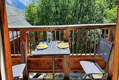 Refugio alpino con balcón y aparcamiento.