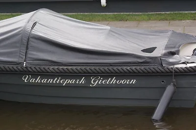 Huisje aan het meer met boot