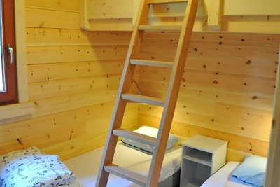 Modernes Holzchalet im Wald, mit Holzofen