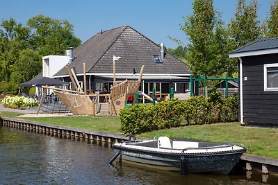 Huisje aan het meer met boot