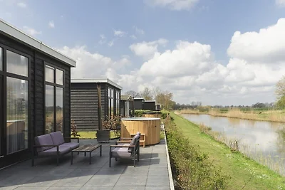 Prachtige blokhut aan de rivier met bubbelbad