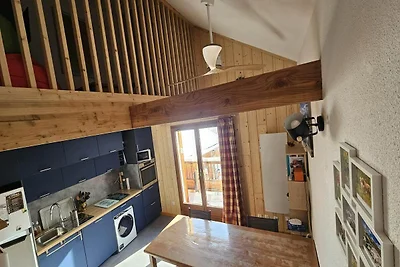Refugio alpino con balcón y aparcamiento.