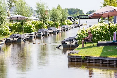 Huisje aan het meer met boot