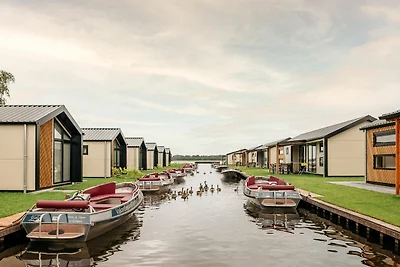 Huisje aan het meer met boot