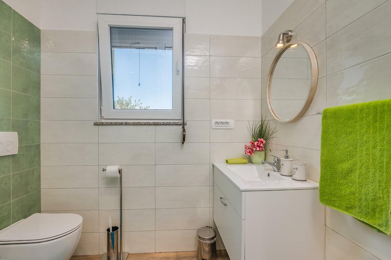 Badezimmer mit lila Akzenten, moderner Ausstattung und Spiegel