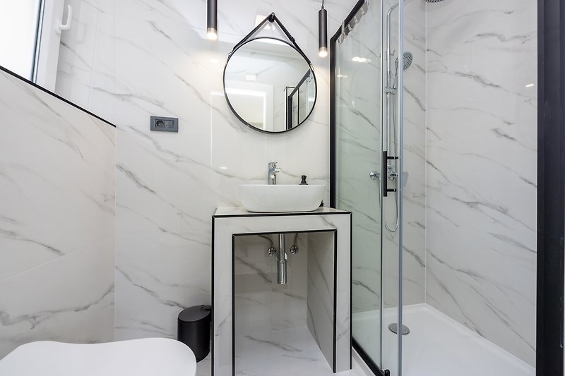 Schönes Badezimmer mit stilvoller Einrichtung und Glaswand.