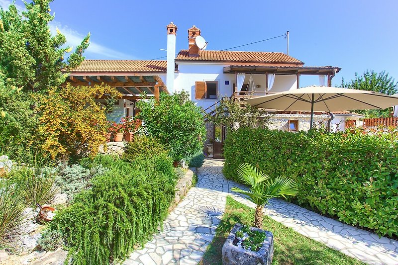Ein charmantes Haus mit einem gepflegten Garten und einer malerischen Landschaft.