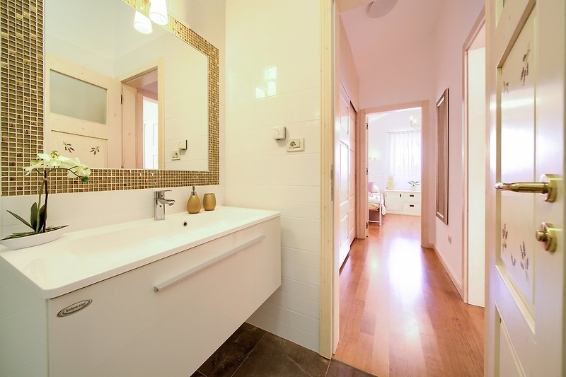 Ein stilvolles Badezimmer mit Spiegel, Waschbecken und Holztür.