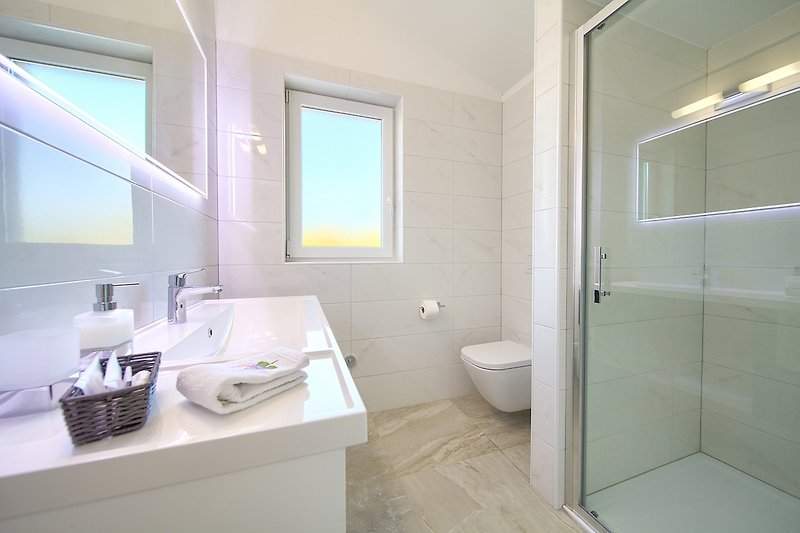 Gemütliches Badezimmer mit Holzboden und lila Akzenten.