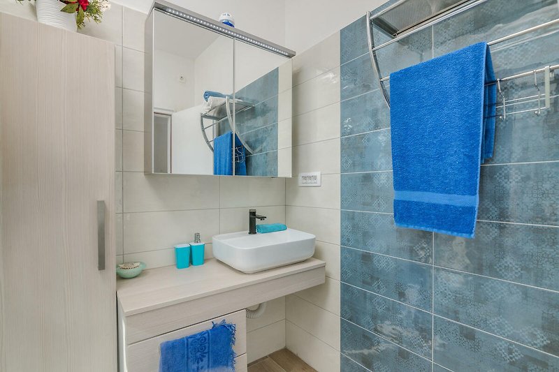 Badezimmer mit lila Akzenten, moderner Ausstattung und Spiegel.