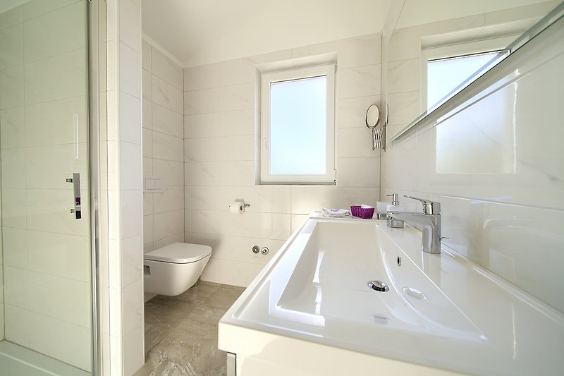 Schönes Badezimmer mit lila Akzenten und Holzboden.