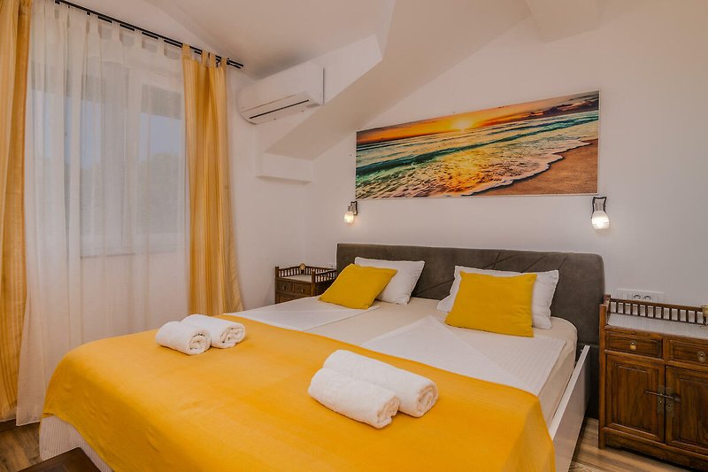 Gemütliches Schlafzimmer mit Holzmöbeln, gelben Vorhängen und bequemem Bett.