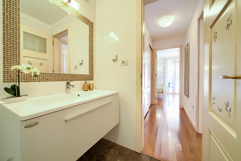 Ein stilvolles Badezimmer mit Spiegel, Waschbecken und Holzmöbeln.