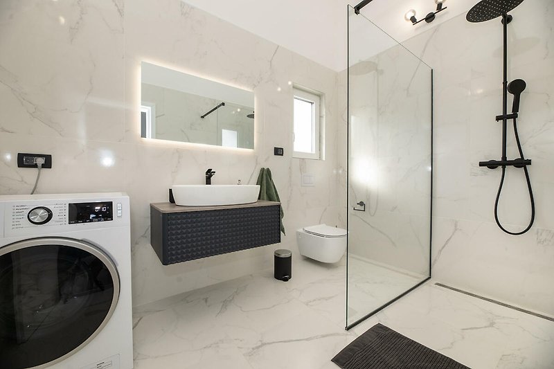 Moderne Badezimmerausstattung mit Spiegel, Waschbecken und Dusche.