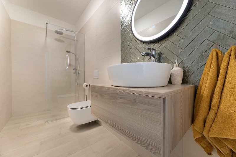 Modernes Badezimmer mit stilvoller Einrichtung und elegantem Spiegel.