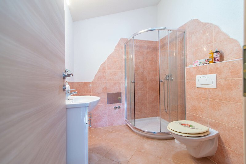 Ein modernes Badezimmer mit lila Waschbecken und Holzdetails.