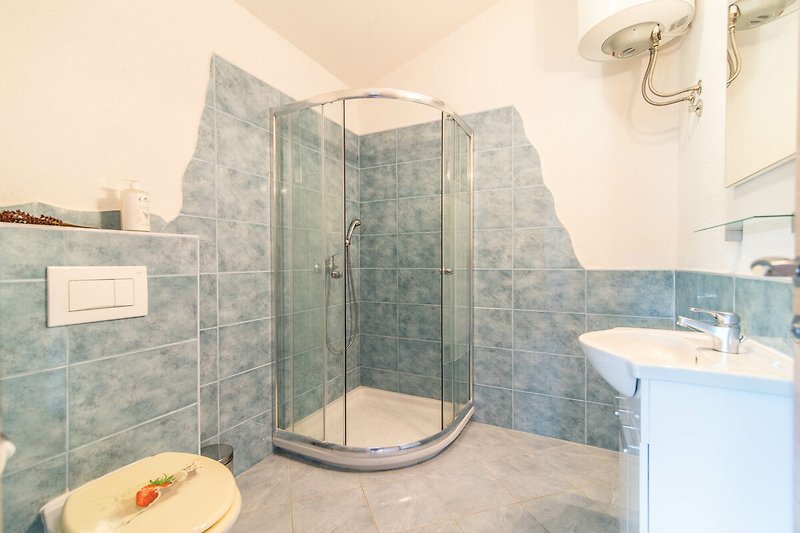 Schönes Badezimmer mit Dusche, Spiegel und Holzboden.