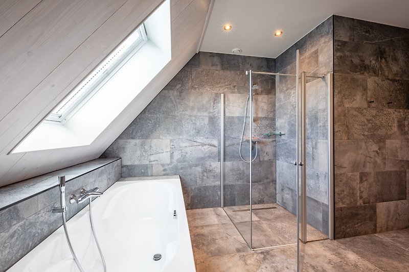 Modernes Badezimmer mit Dusche, Badewanne und Fliesen.