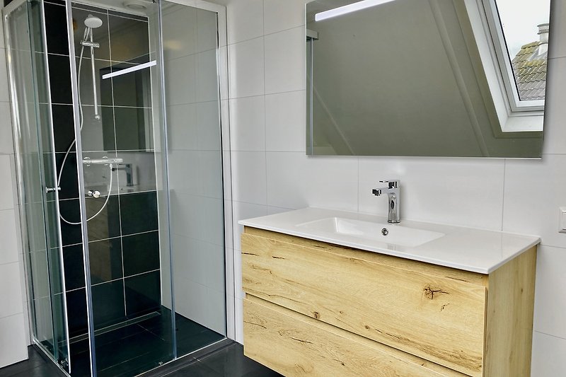Prachtige badkamer met houten meubels en een spiegel.