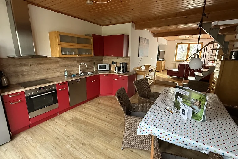 Großzügiger Wohnraum mit Sofa, Esstisch, Holzmöbeln und TV.
