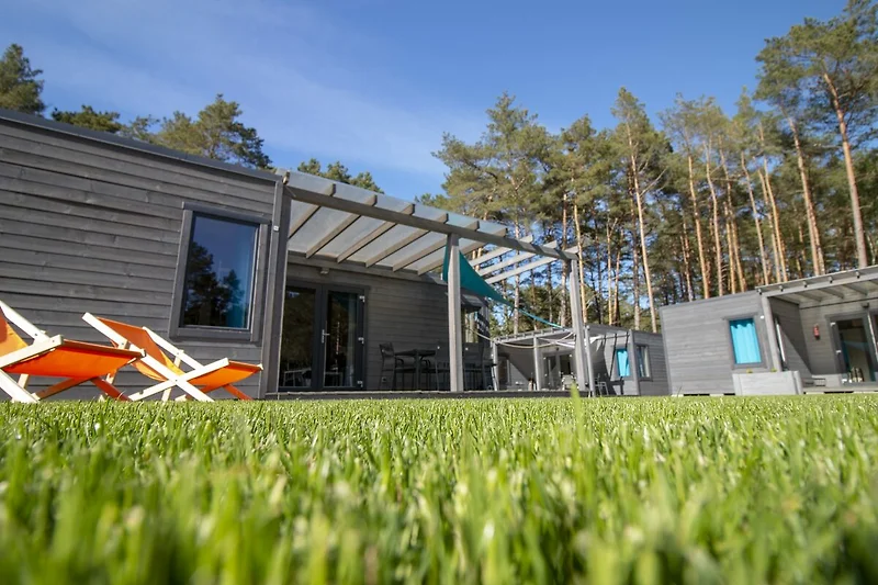 Großer Garten mit Holzdeck, Sitzgruppe und Gartenhaus im Grünen.